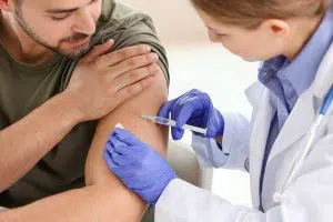 Photo of man receiving vaccine from a nurse