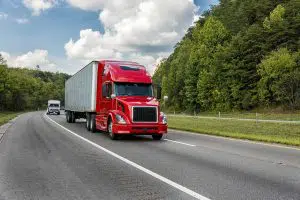 Photo of a red semi truck driving on the road