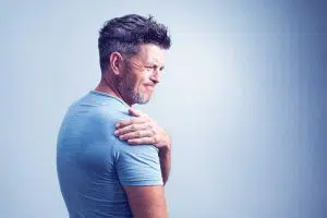 photo of man holding his shoulder, in pain