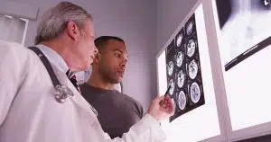 photo of a doctor and patient looking over brain scans together