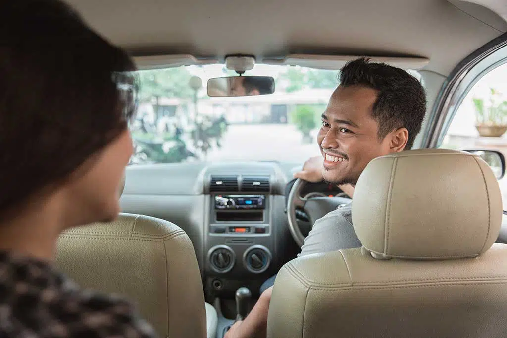Photo of rideshare driver smiling to customer