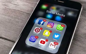 close up of a phone with a folder of social media applications and notification bubbles