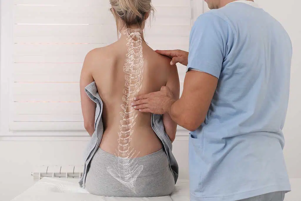 Photo of a doctor examining a woman's spine