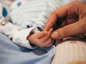 Mother holding child's hand