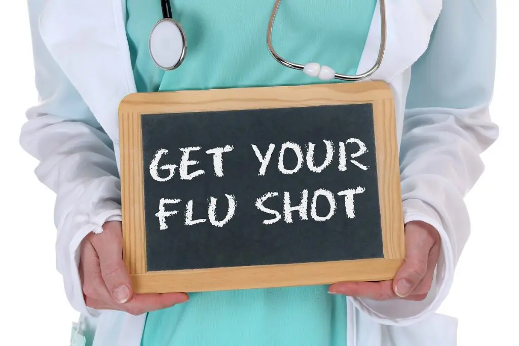Doctor Holding Get Your Flu Shot Sign