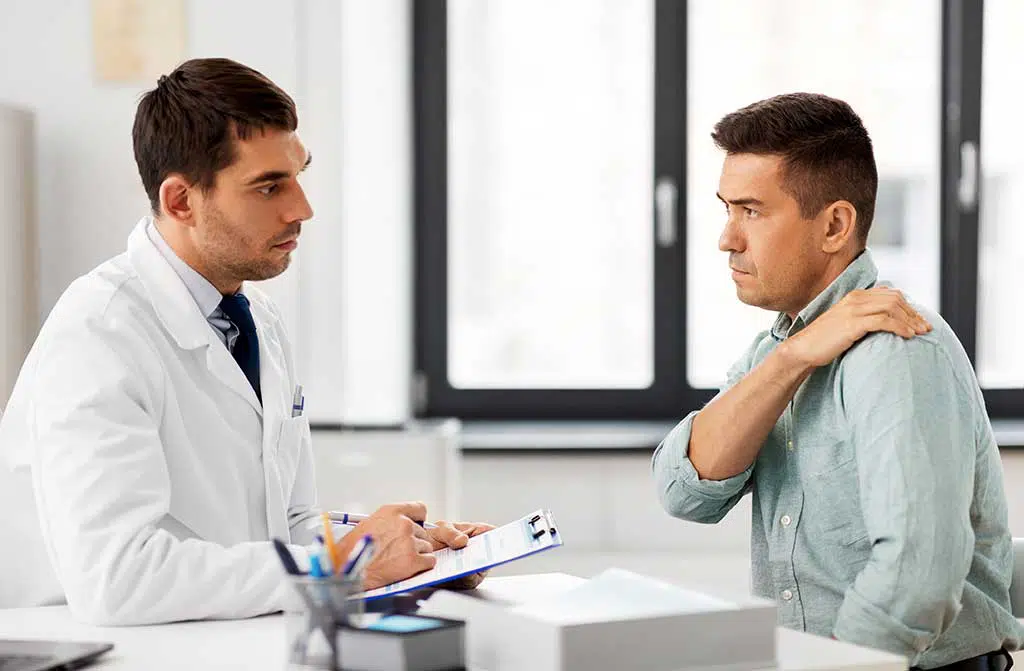 Photo of a doctor and patient evaluating shoulder pain